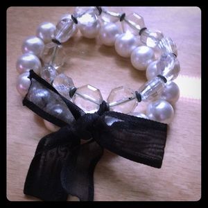 Two bracelets connected with bow